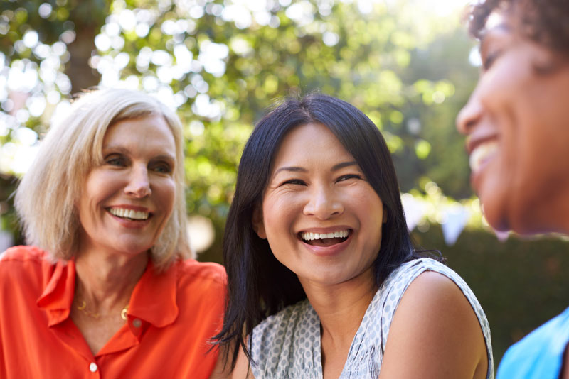 three dental patients smiling with new dental implants.