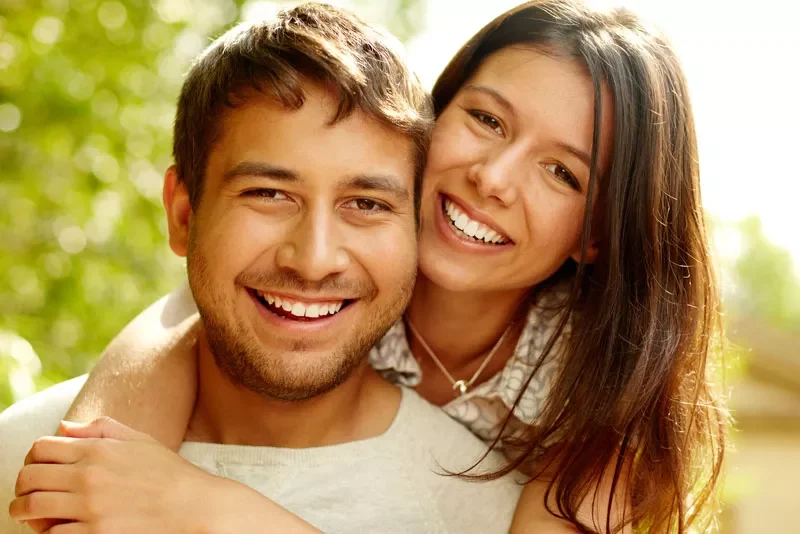 Smiling young couple hugging outdoors